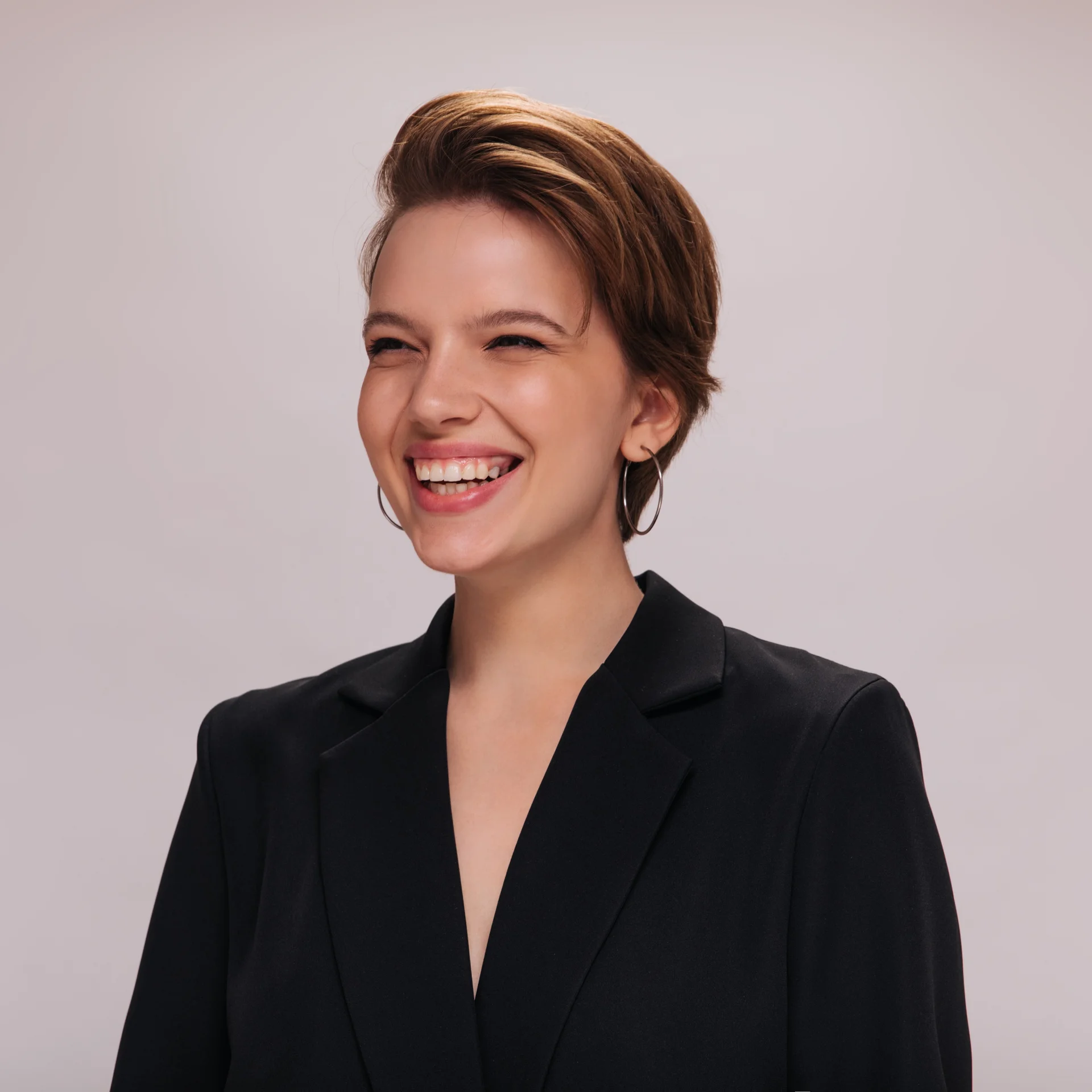 Foto de perfil de mujer de ~35 años, sonriente, fondo neutro, estilo profesional casual.